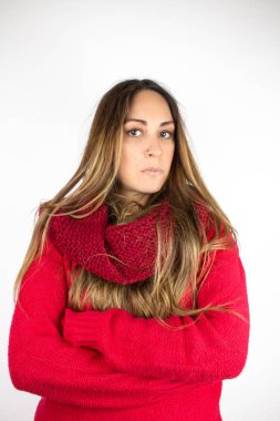 Beyaz üzerine izole edilmiş kırmızı kazak ve eşarp giyen güzel genç bir kadının portresi.