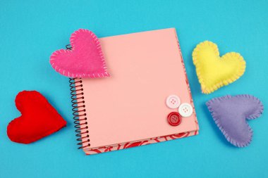 mavi kalpler ve düğmeler ile pembe not defteri üst görünümü 