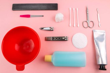 Manikür ve pedikür araçları pembe bir arka plan üzerinde