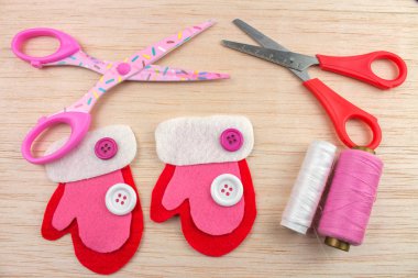 Eldivenler, konu düğmeleri ve makaslar ahşap masa olan pembe dekoratif Noel hissettim 