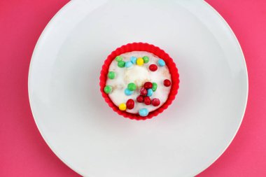 Pembe bir arka plan üzerinde Cupcake vanilya buzlu