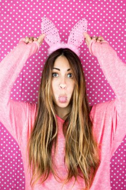 Tavşan kulaklı güzel bir kadının portresi pembemsi arka planda buruşuyor.