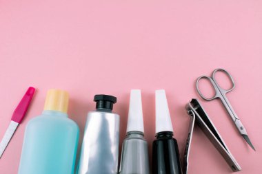 Manikür ve pedikür araçları pembe bir arka plan üzerinde