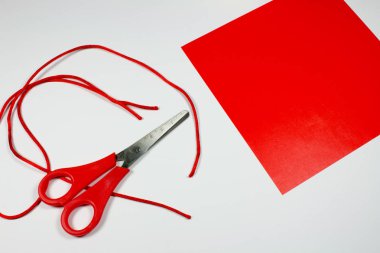 kırmızı dekoratif kağıt, halatlar ve üzerinde beyaz izole makas
