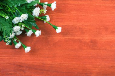 Ahşap masa üzerinde beyaz bahar plastik çiçekler