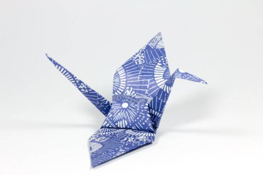 beyaz zemin üzerine mavi origami kuş