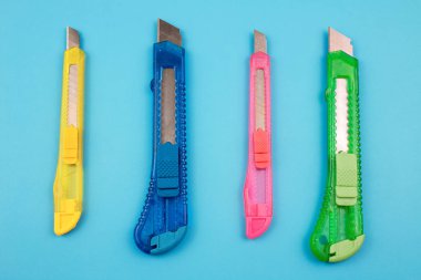 Kağıt arka plan üzerinde renkli plastik kesiciler
