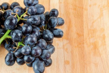 Ahşap masa üzerinde mavi üzüm demet