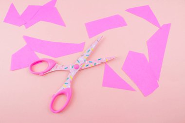 pembe Pembe bir arka plan üzerinde kağıt parçasının makasla