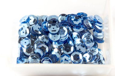 close-up shot of blue sequins in box on tabletop