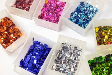 close-up shot of colorful sequins in boxes on tabletop