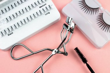 Pembe Arka Plan Üzerine Makyaj Yapışkanlı Kirpik Fişekleri ve Araçları