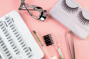 Pembe Arka Plan Üzerine Makyaj Yapışkanlı Kirpik Fişekleri ve Araçları