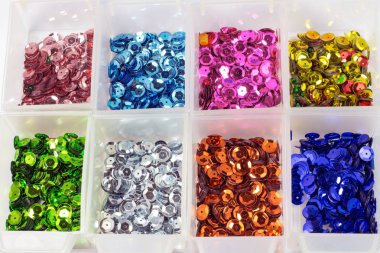 close-up shot of colorful sequins in boxes on tabletop