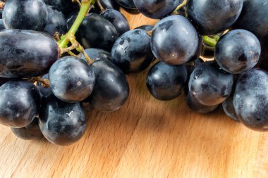 Ahşap masa üzerinde mavi üzüm demet