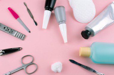 Manikür ve pedikür araçları pembe bir arka plan üzerinde