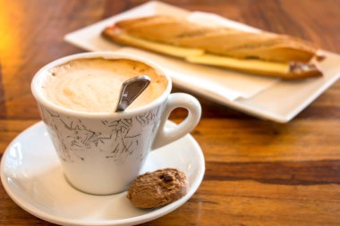 Kahve fincanı ve çerez bir tablo çubuğundaki.