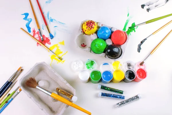 Huevos Pascua Pintados Sobre Mesa Blanca Con Pinturas Purpurina Pinceles —  Fotos de Stock