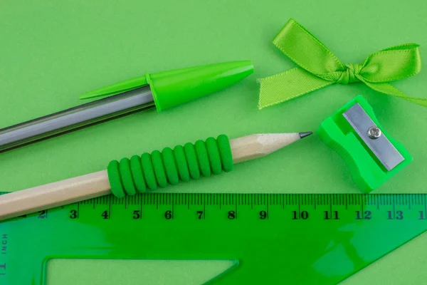 School green tools on green paper background.