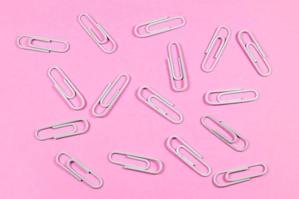 ピンクの背景に分離されたホワイト ペーパー クリップ — ストック写真