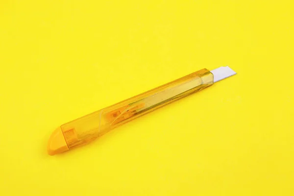 Kağıt Arka Plan Üzerinde Sarı Plastik Kesici — Stok fotoğraf