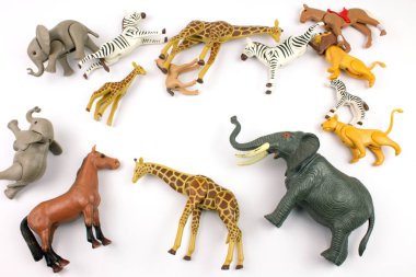 close-up shot of various toy animals made of plastic on white background