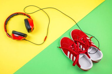 Barcelona, İspanya. Nisan 10,2018. Kırmızı Adidas ayakkabı ve renkli backgorund üzerinde kırmızı headphoens.