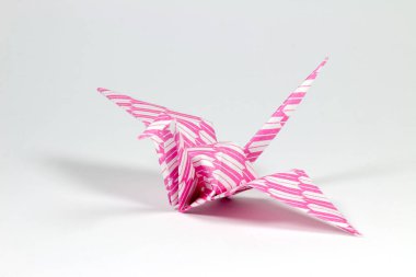 beyaz zemin üzerine pembe origami kuş