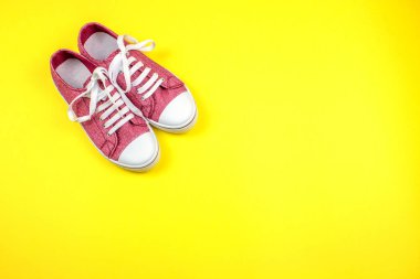 sarı arka planda canlı spor ayakkabı çifti 