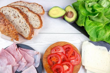 ekmek, jambon, peynir, domates, avokado ve salata parçaları