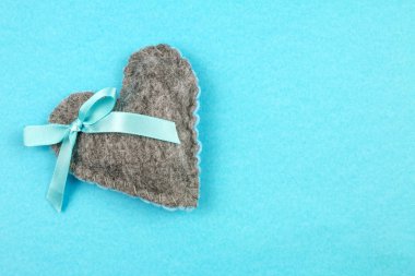 Üstten Görünüm gri mavi arka plan üzerinde yay ile kalp hissettim 