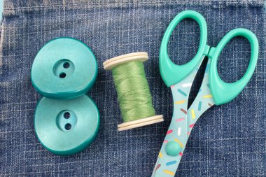 kot arka plan üzerinde plastik düğmeler, konu ve makas Üstten Görünüm