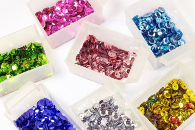 close-up shot of colorful sequins in boxes on tabletop