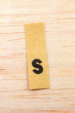 Ahşap yüzeye yapıştırılmış çıkartma üzerindeki harflerin yakın çekim görüntüsü