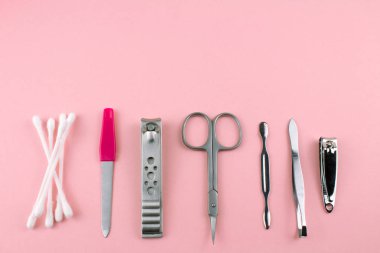 Manikür ve pedikür araçları pembe bir arka plan üzerinde