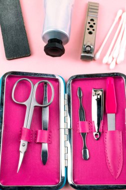 Manikür ve pedikür araçları pembe bir arka plan üzerinde