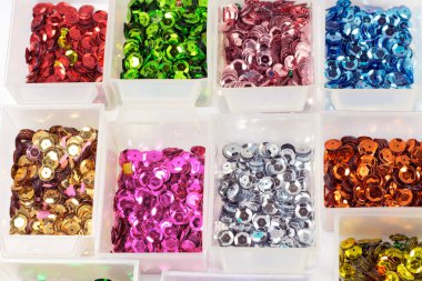 close-up shot of colorful sequins in boxes on tabletop