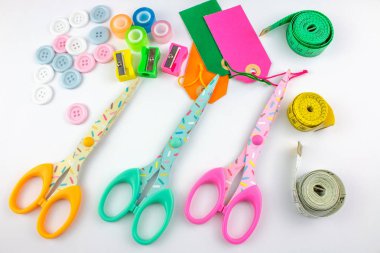 Ölçme bantları, renkli makas, düğmeler, sharpeners ve beyaz arka plan üzerinde Etiketler
