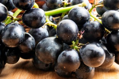 Ahşap masa üzerinde mavi üzüm demet