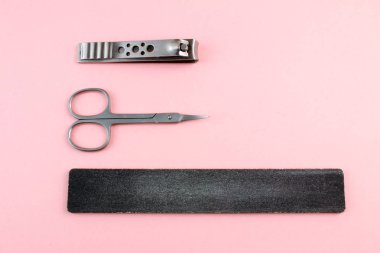 Manikür ve pedikür araçları pembe bir arka plan üzerinde