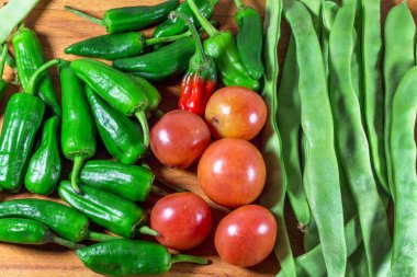 ahşap masada yeşil fasulye, acı biber ve kırmızı domates  