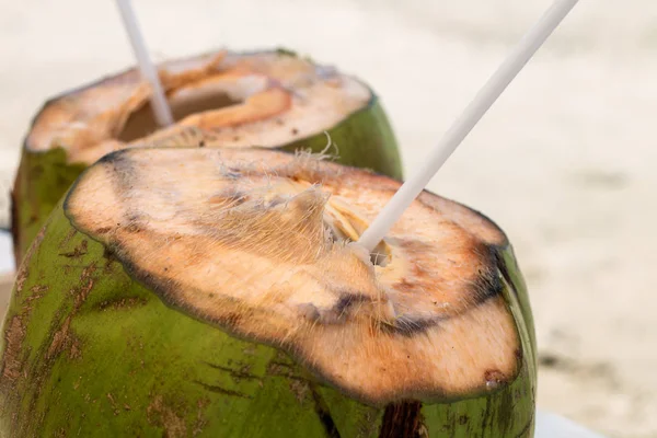 Coconut Drink with straws at the Beach