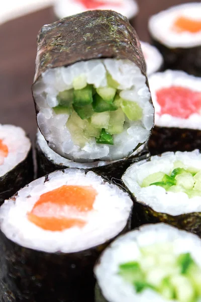 close up of sushi rolls with tuna, cucumber and salmon