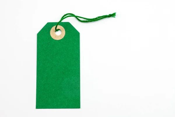 green paper tag tied with string isolated on white