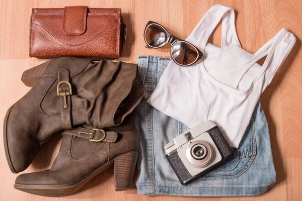 top view shot of stylish female clothes with vintage camera on wooden table