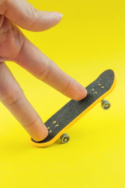 Man Spelen Met Mini Skateboard Speelgoed Gele Achtergrond — Stockfoto