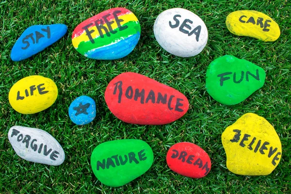 Colored rocks with words on green grass