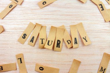 Cumartesi günü ahşap yüzeye yapıştırılmış çıkartmalarla çekilen yakın çekim.