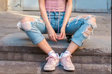 Barcelona, İspanya. 7 Mart 2018: Kentsel arka plan üzerinde beyaz şeritler ile eski pembe adidas ayakkabı giyen genç kadınla kaymak,.