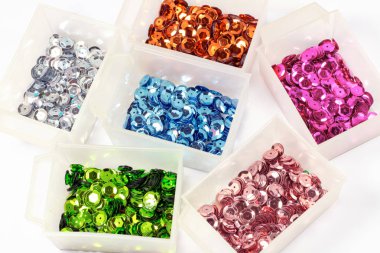 close-up shot of colorful sequins in boxes on tabletop